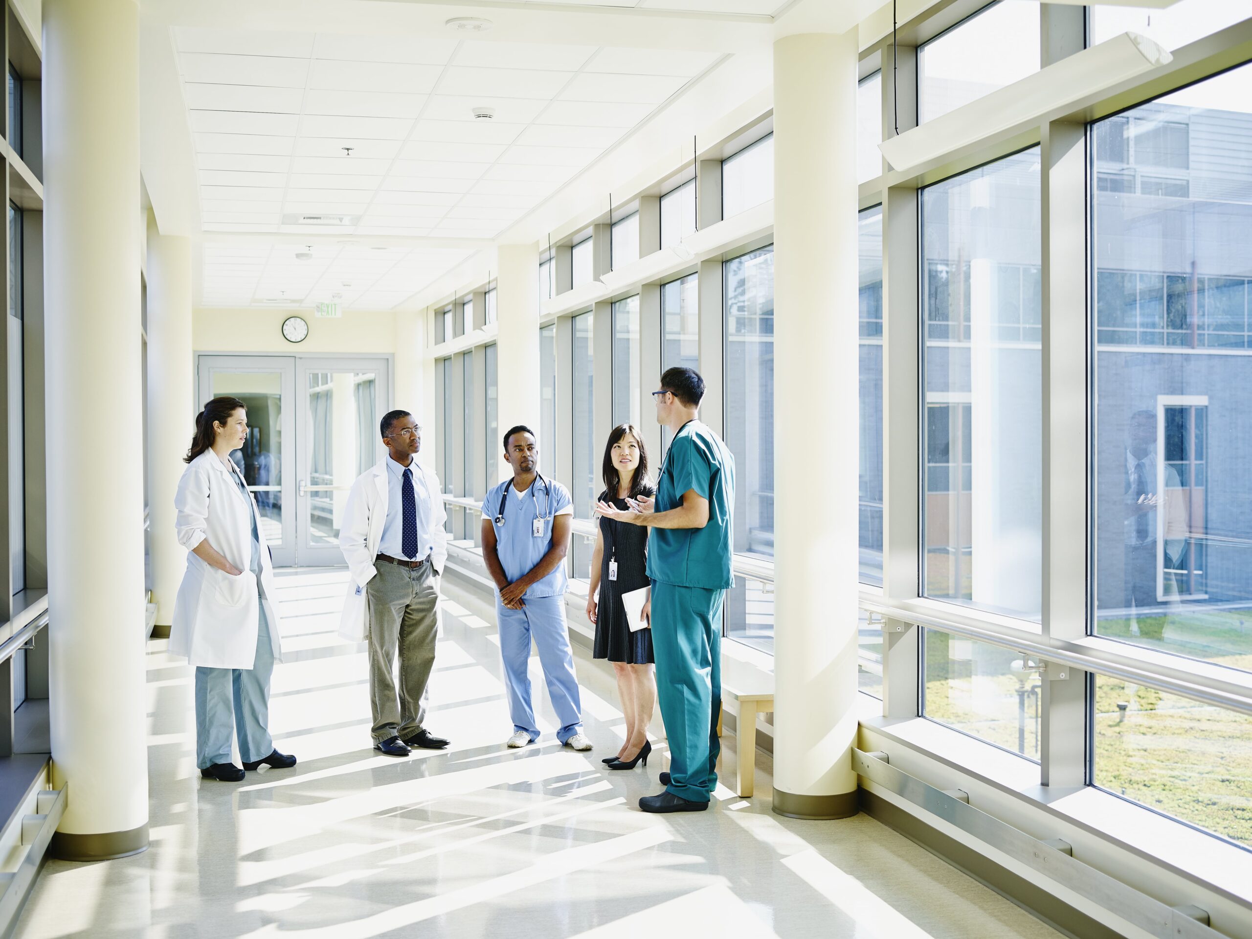 Artsen overleggen in de hal van een ziekenhuis met veel zonlicht